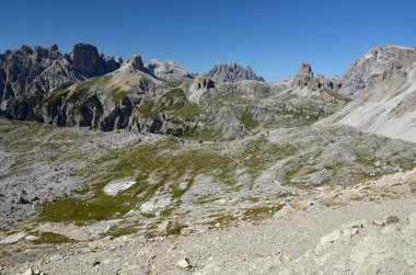 Torre dei Scarperi (Schwabenalpenkopf), Tre Cime çevresindeki dairesel yoldan çekilmiş. Fotoğraf, uzaktaki Dreizinnenhutte dağ kulübesini gösteriyor.