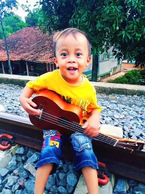 Cianjur, Jawa Barat, Endonezya, 3 Aralık 2020, Potret seorang anak kecil membawa gitarnya di cianjur, propinsi jawa barat, OK 29, 2020