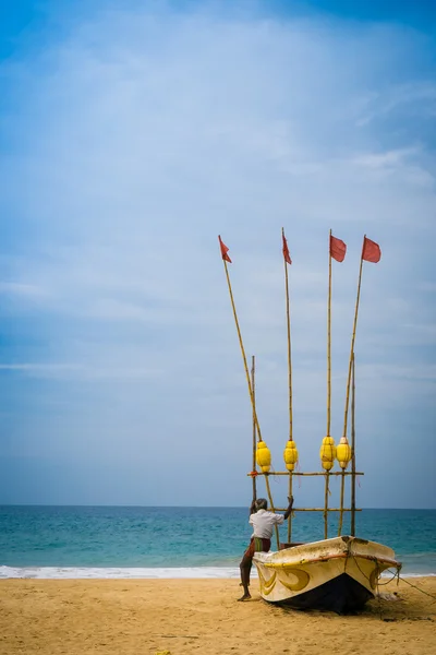 An old man sits on his boat looking out to sea — Stock Photo, Image