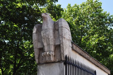 Eski bir çitteki kartalın taş görüntüsü. Kapıları olan