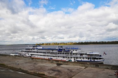 Rıhtımda bir yolcu gemisiyle nehir kenarı. Yaz aydınlık bir gündür..