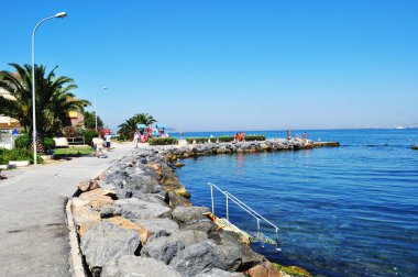 Sur ve deniz manzarası var. Kumsal, denize giden büyük taşlar ve merdivenler..