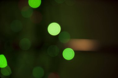 Bokeh, soyutlama. Koyu yeşil arka planda bulanık yeşil halkalar.
