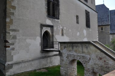 Kemerli taş bir merdiven ve evin girişinde zincirleri ve parmaklıkları olan küçük bir köprü..