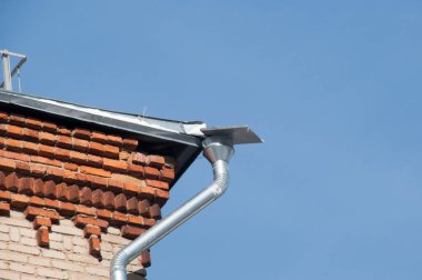 Binanın çatısında güneşli bir kış günü manzarası. Boru kardan metal bir levha ile kaplanmış..