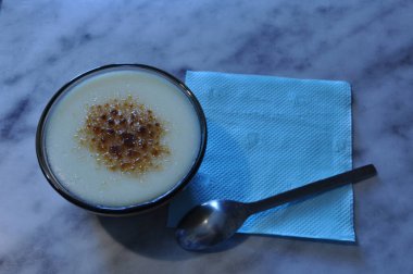 Masada pirinç unu tatlısı var. Tatlı, çay kaşığı ve mavi arka planda peçete. Yiyecekler. Arkaplan.