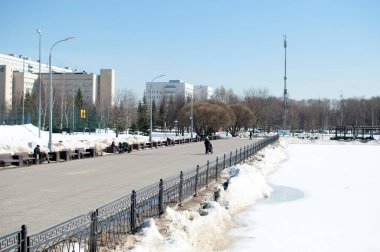 Kışın şehir parkının panoramik manzarası. Yürüyen insanlarla dolu parkta..