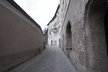 Eski kasabanın ıssız bir caddesinde taş kaldırımlar ve binalarda kemerler var..
