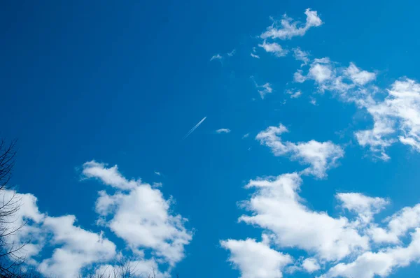 Num Céu Azul Com Nuvens Rasto Branco Avião Voador — Fotografia de Stock