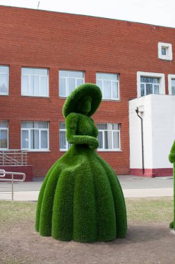 Şehir heykeli. Yapay yeşil malzemeden yapılmış şapkalı bir kadın figürü. 19 Nisan 2021 Moskova, Rusya