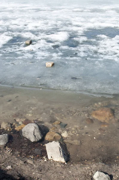 春のパノラマ 氷のない池のほとりの石 — ストック写真