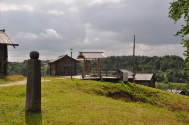 Köyün panoramik manzarası, ahşap evler, yeşil çimenler ve ufukta orman olan bir açıklık. 03 Ağustos 2020, Arkhangelsk, Rusya