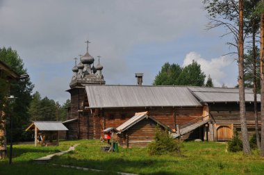Eski ahşap bir kilise ve büyük bir ahşap ev manzarası. 03 Ağustos 2020, Arkhangelsk, Rusya.