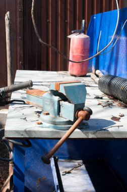 Masa, beyaz kapaklı tezgah ve eski paslı mengene. Arkaplan, tasarım.