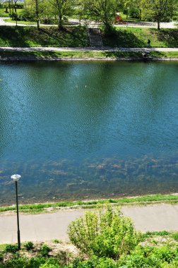 Şehrin göletinin üst kısmının manzarası. Kıyı şeridi ve yeşillik.