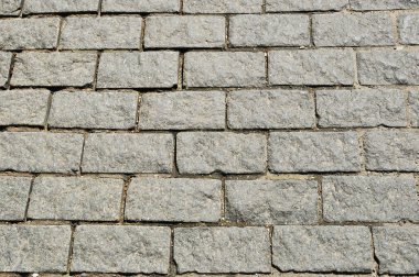 Dikdörtgen granit taşlardan yontulmuş taşlar. Arka plan, doku. Tasarım. Kaldırımın bir parçası..