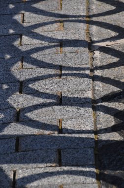 Taş kaldırımda duran siperin gölgesi. Aydınlık ve güneşli bir günde Yerdeki gölge.