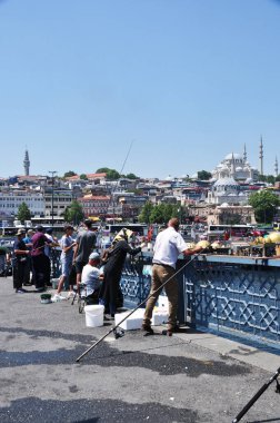 Kasaba halkı köprüden balık tutuyor. 11 Temmuz 2021, İstanbul, Türkiye. Güneşli, şehirde yaz günü.