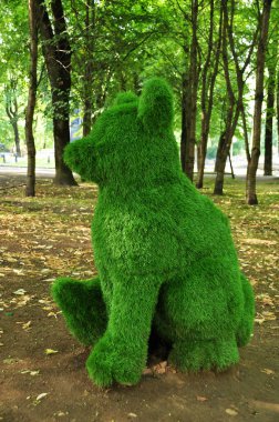 Testis taşı. Kesilmiş yeşil çalılar, oturan ayı heykelciği. 02 Ağustos 2021, Smolensk, Rusya.