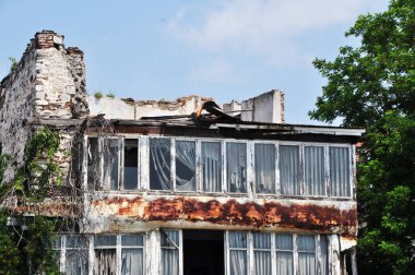 Eski tuğla ev. Çatısız eski bir ev ve camsız bir pencere. Mavi gökyüzüne karşı bir ev