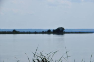 Arka plan bulanık, adası olan büyük bir göl manzarası. Odaklanma, Lake. Bokeh.