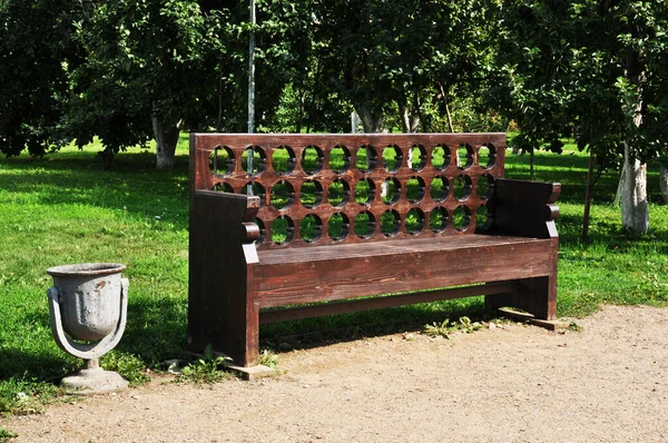 Park wooden bench. View of the bench from the city park. Carved wood bench back.