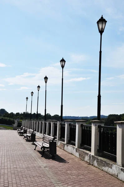 Nehir kenarındaki bankların ve fenerlerin manzarası. Güneşli yaz günü.