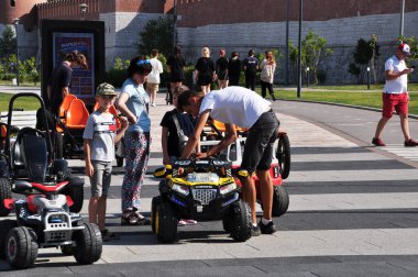 Ebeveynler çocukların arabasını yolculuk için hazırlıyorlar. Açık hava sporları. 16 Ağustos 2021, Tula, Rusya.