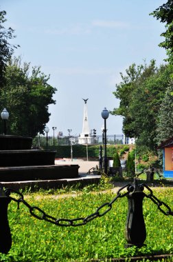 Şehir parkının panoramik manzarası. Anıt ve büyük çitin manzarası. Yaz günü.