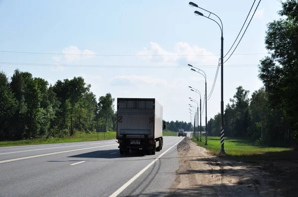 Yoldan geçen arabalarla otoyol manzarası. Yaz trafiği. Kamyonlar yol boyunca gidiyor. 03 Ağustos 2021 Bryansk, Rusya.
