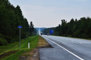E-101 yolu. Arabalı bir yol ve Bryansk ve Dubrovka şehirlerine giden mavi bir yol tabelası. 30 Temmuz 2021, Bryansk, Rusya.