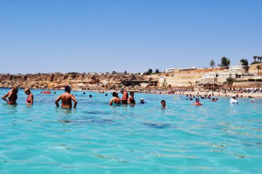 İnsanlar tatil köyünde denizde yüzerler. Club Fanara 'daki plajın panoramik manzarası. 10 Eylül 2010, Sharm El Sheikh, Mısır.