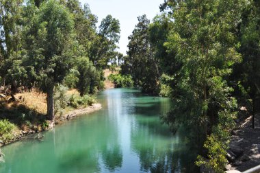 Ürdün Nehri 'nin panoramik manzarası. Büyük ağaçları olan Hıristiyanlar için kutsal bir nehrin kıyısında..