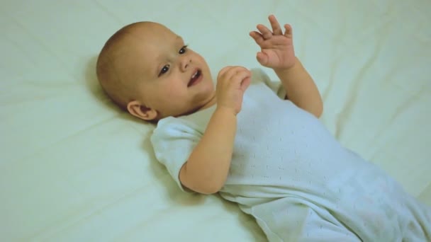 Мальчик играет с одеялом и улыбается — стоковое видео