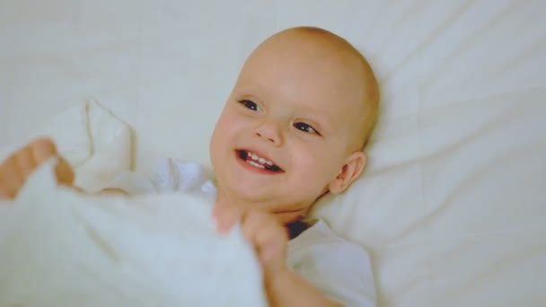 Boy plays with blanket and smiling — Stock Video