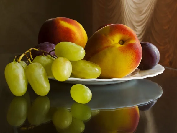 The fruit on the plate with the reflection in the mirror countertop — Stock Photo, Image