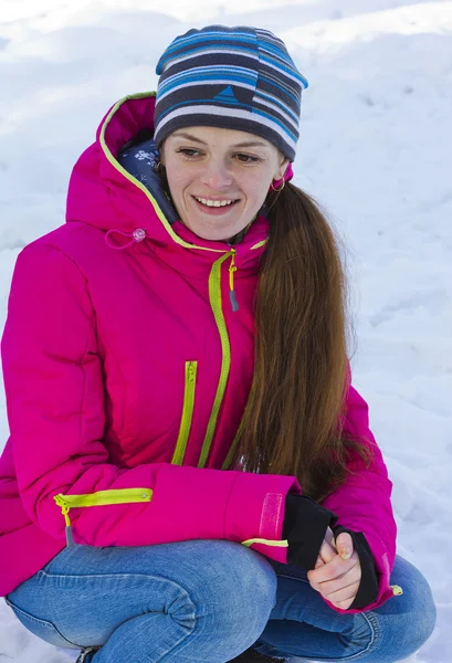 Das Mädchen in der roten Jacke in der Hocke — Stockfoto