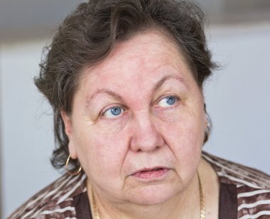 Yaşlı bir kadın birisiyle konuşuyor. Bir yakın çekim portre