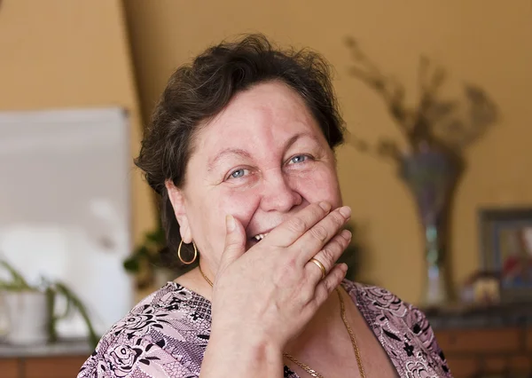 A mulher ri, cobrindo a boca com a mão — Fotografia de Stock