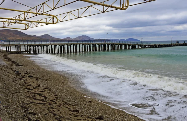 Playa desierta, muelle con mal tiempo . — Foto de Stock