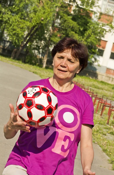 La mujer hace ejercicios con una pelota de fútbol — Foto de Stock