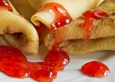 Pannenkoeken met aardbeienjam op een witte plaat. Closeup