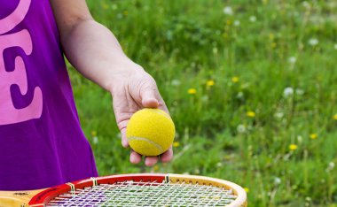 Arka plan yeşil çim üzerinde bir tenis topu ile el atlet
