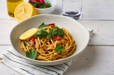 spagetti makarna aglio e olio ve biber taneli maydanozlu sarımsak beyaz arka planda