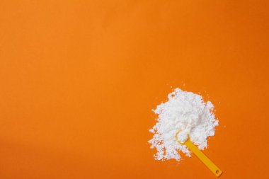 Turuncu arkaplan fotokopi alanındaki spor takviyesi kreatin tozu