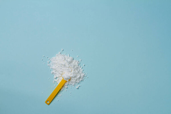 sports supplement creatine powder on light blue background copy space