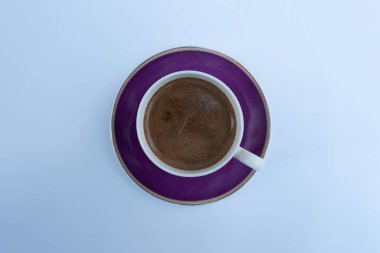 Köpüklü kapuçino ya da latte, parlak arka planda kapalı mavi kahve fincanı manzaralı. Kafe ve bar, barista sanat konsepti..