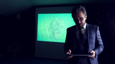 Takım elbiseli iş adamı tabletle sunum yapıyor