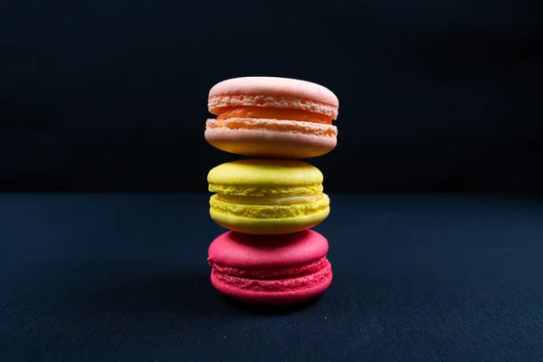 Colourful stack of macaroons isolated on plain black background. Copyspace