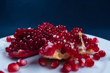 Taze, tatlı, kabuklu nar, koyu siyah arka planda kırmızı tohumlar, üst manzara, sağlıklı besin meyveleri.